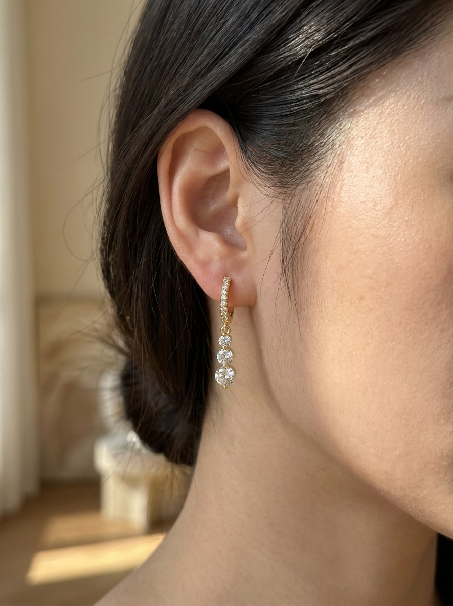 Model draagt gouden moissanite hangoorbellen